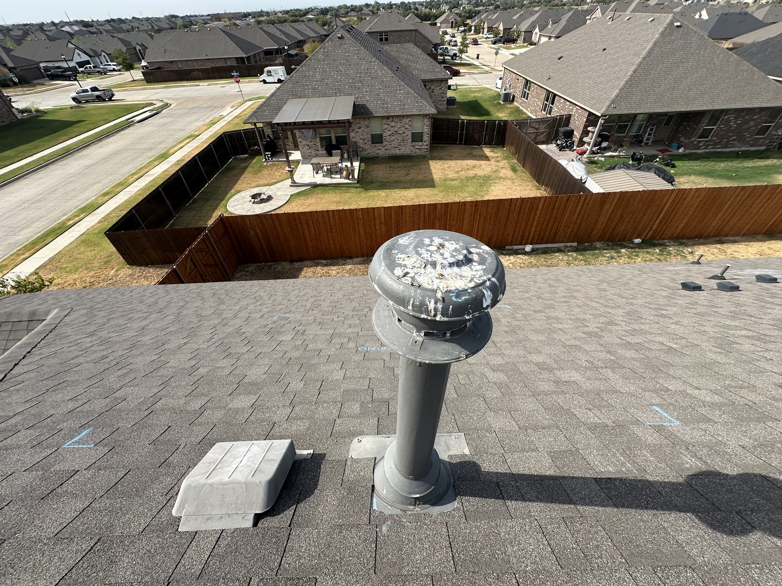 Asphalt shingles with a plumbing vent and minor debris on roof.