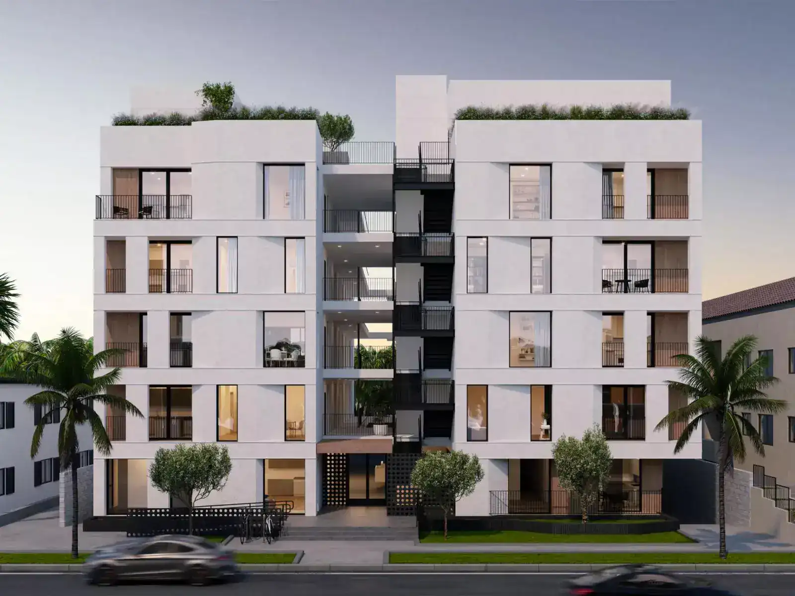 Modern white multi-story residential building with large glass windows and black metal balconies, featuring rooftop greenery.