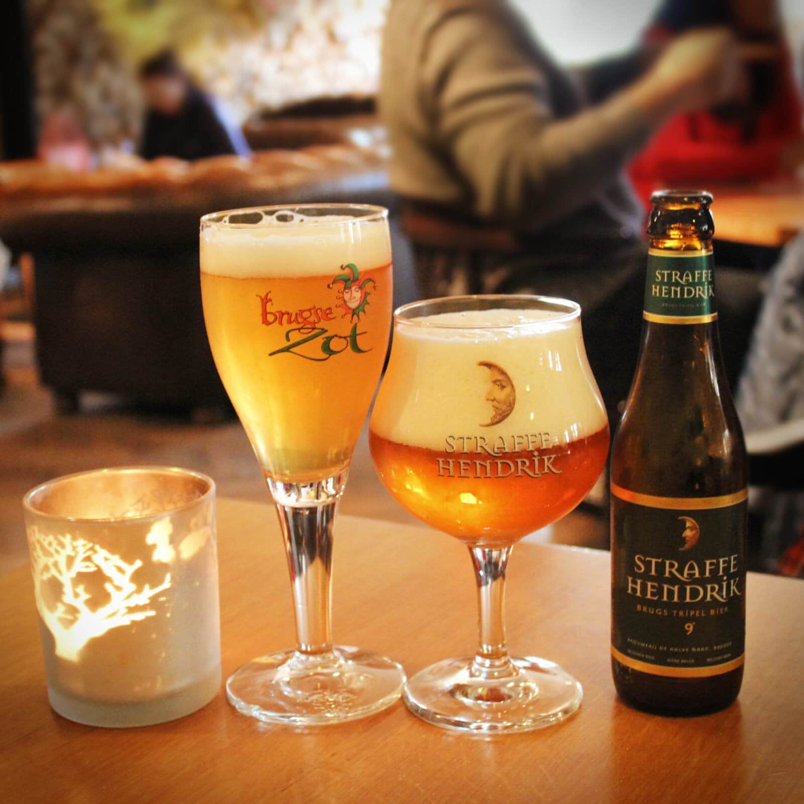 Two Belgian beers at Halve Man Brewery, in Brugges, Belgium. The proper way to drink a Belgian beer is with from the bottle, with 2 fingers of foam, in the glass that matches with the beer. And of course, it's always better to drink beer in Belgium itself.Two Belgian beers at Halve Man Brewery, in Brugges, Belgium. The proper way to drink a Belgian beer is with from the bottle, with 2 fingers of foam, in the glass that matches with the beer. And of course, it's always better to drink beer in Belgium itself.