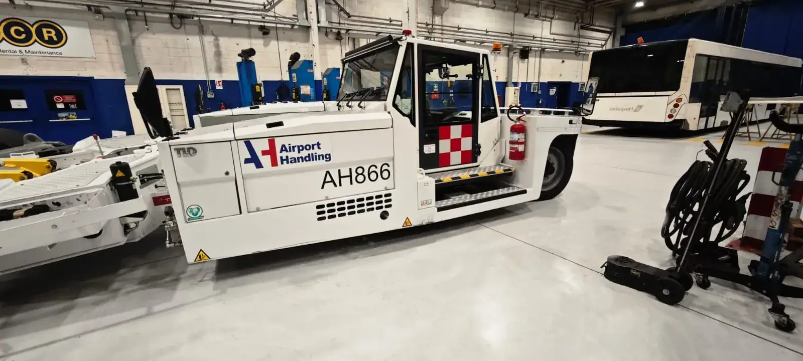 Officina riparazione bus aeroportuali con pavimento in resina epossidica Prima Pavimenti — rivestimento antiolio resistente a idrocarburi, carburanti diesel e carichi concentrati per manutenzione mezzi di ground handling aeroportuale