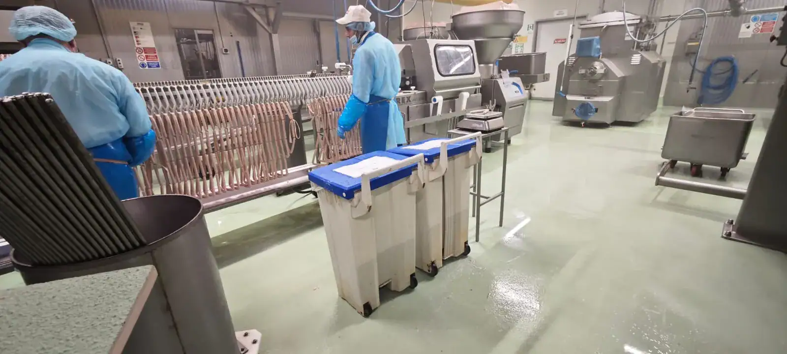 Reparto produzione Salumificio Scarlino con pavimento in cemento poliuretanico Prima Pavimenti — rivestimento autolivellante antiacido resistente a grassi animali e cicli di lavaggio ad alta pressione per industria salumi e insaccati