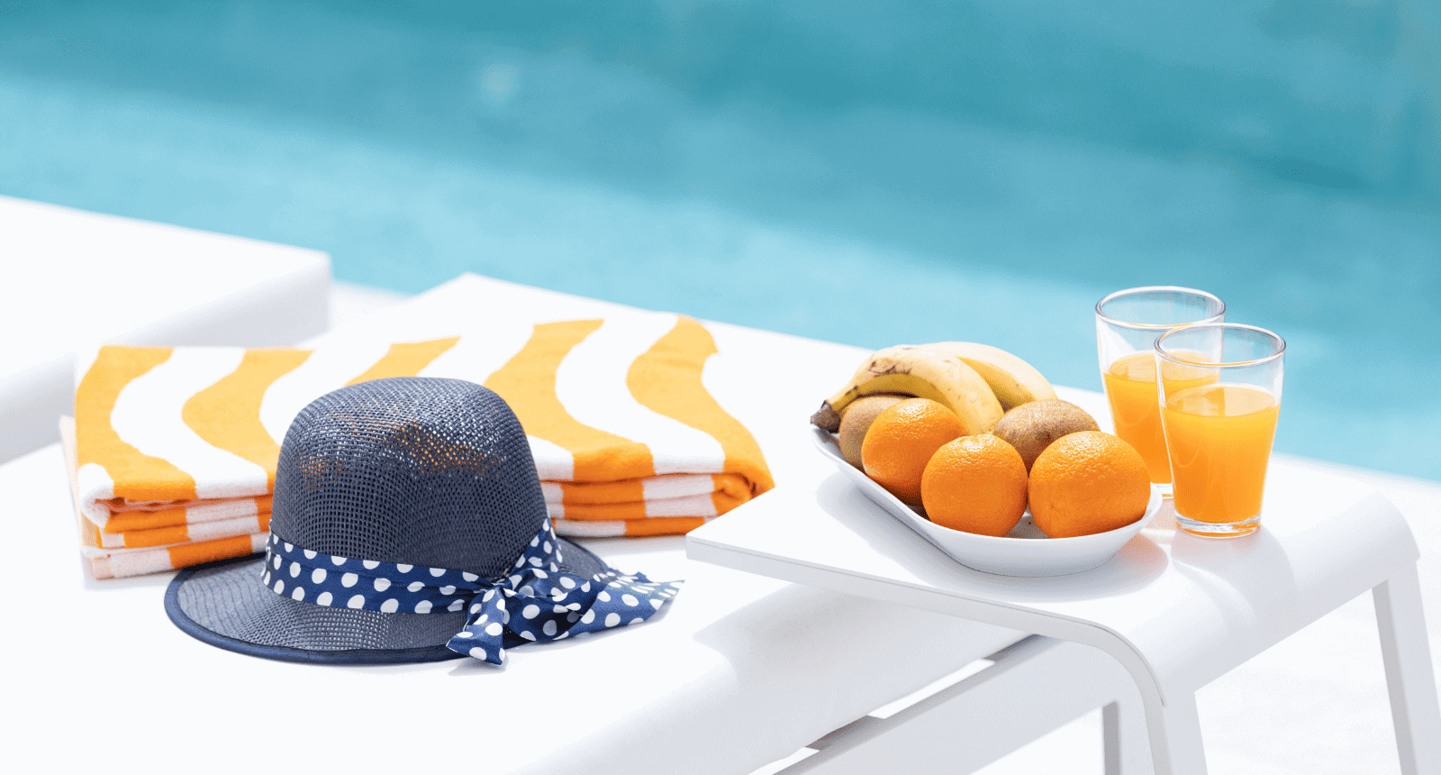 Fruits and hat next to a swimming pool in a luxury villa in Tenerife Property Management