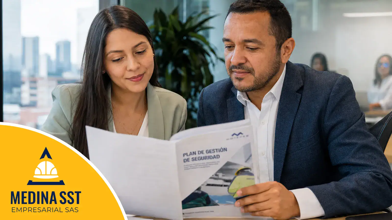 Dos profesionales de una empresa colombiana revisando juntos el documento de roles y responsabilidades del SG-SST