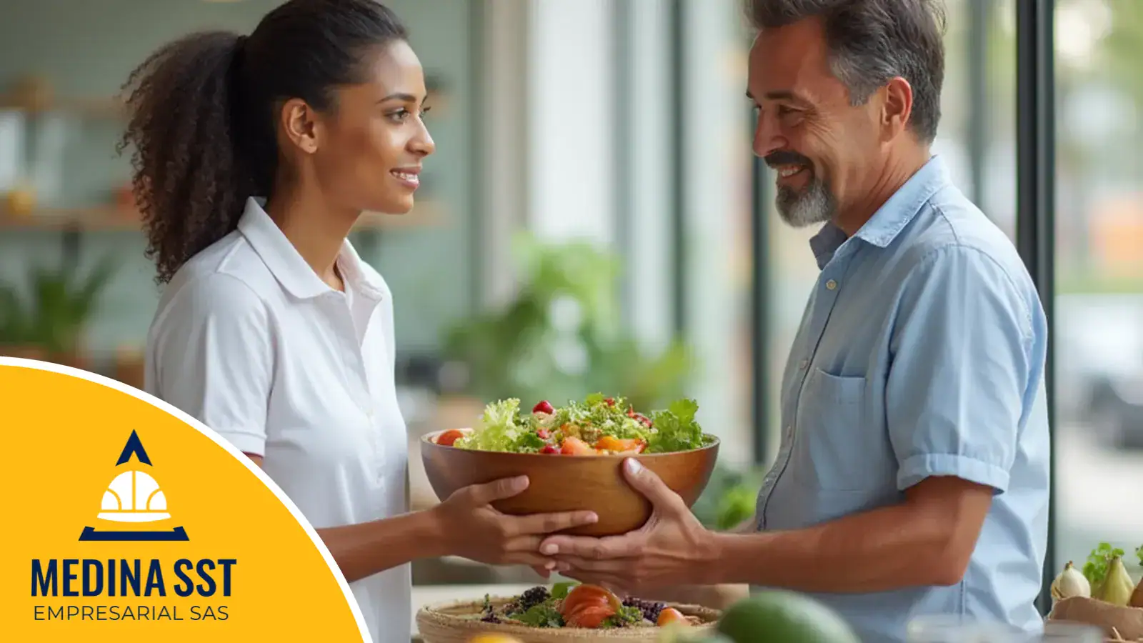 Nutricionista sonriente en el puesto de alimentación saludable de la semana de la salud de una empresa, con verduras y fruta frescas sobre la mesa