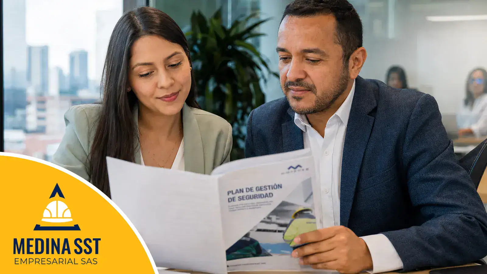 Dos profesionales de una empresa colombiana revisando juntos el documento de roles y responsabilidades del SG-SST
