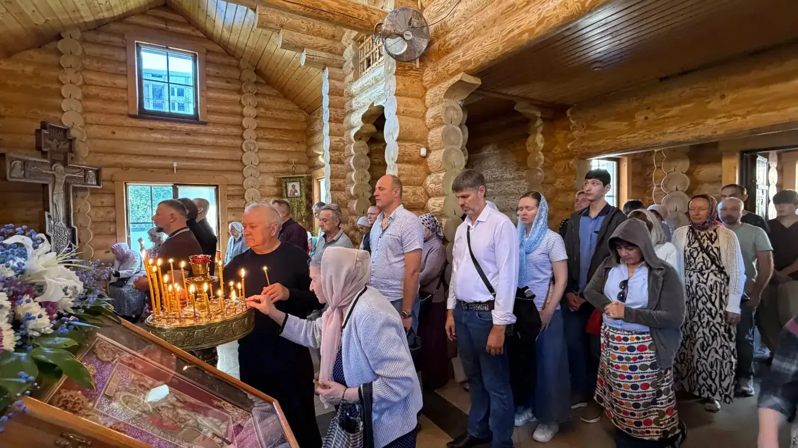 Прихожане ставят свечи во время богослужения
