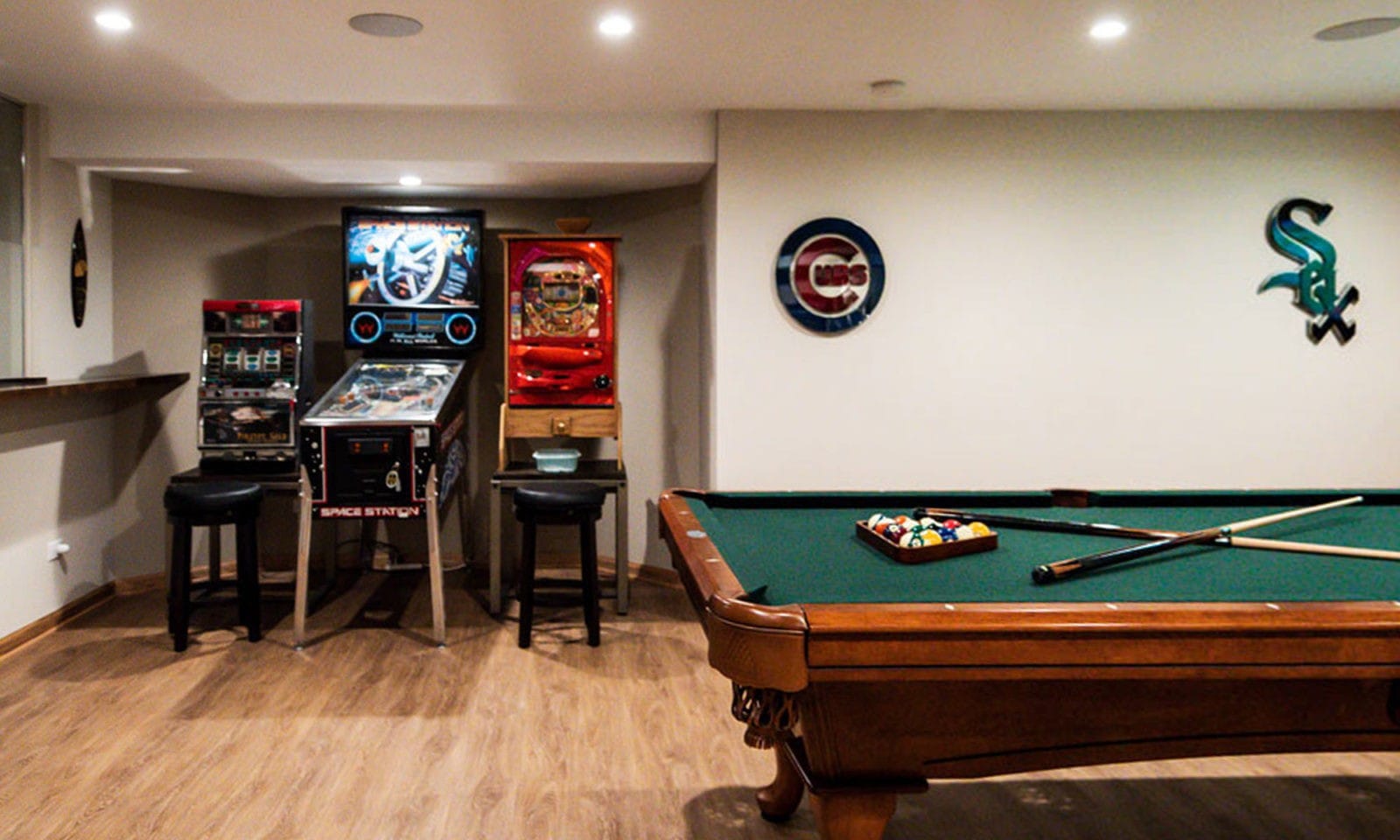 basement remodel with arcade games, pool table, sports signs, recessed lighting, and wood floors