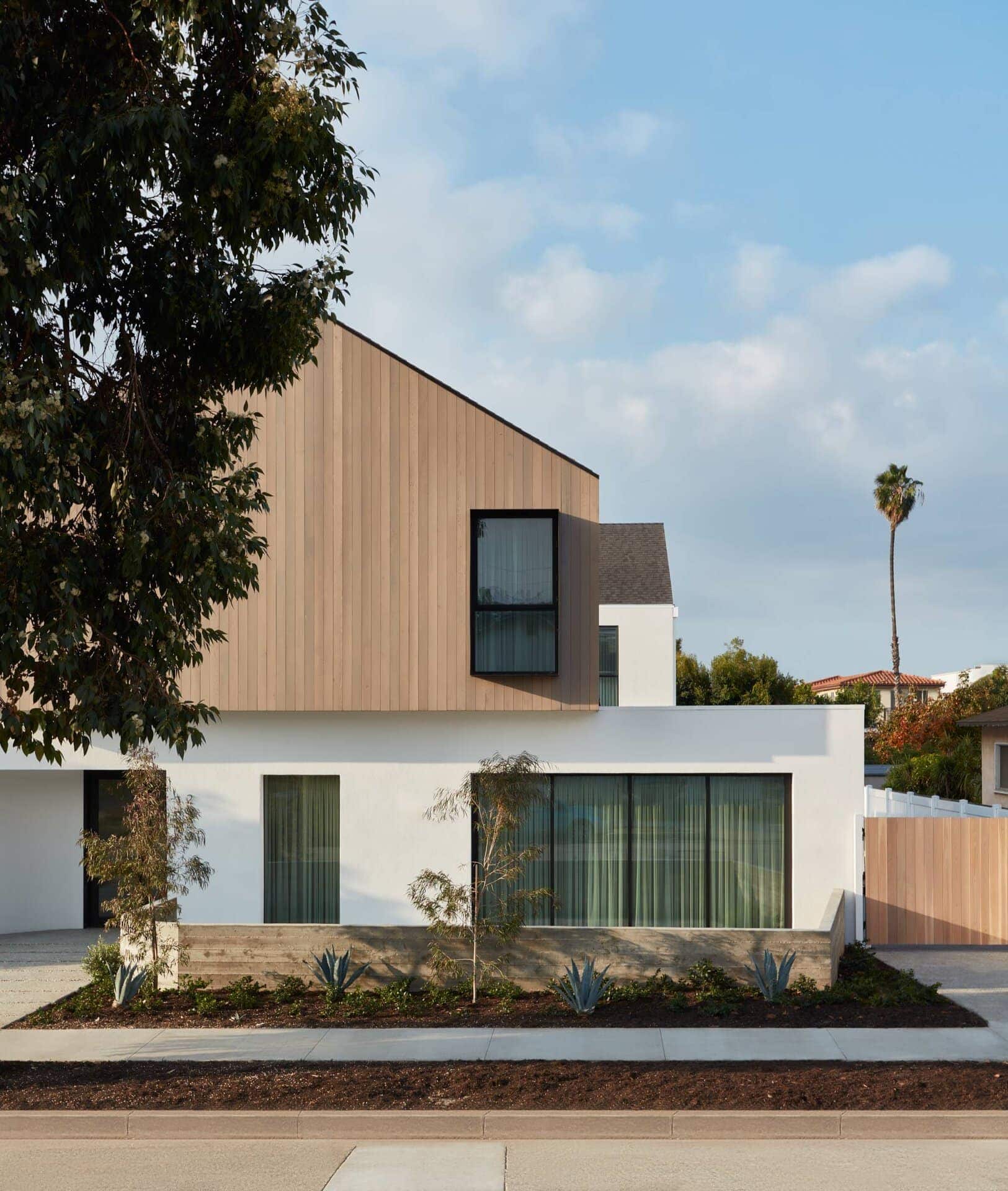 Modern residential house exterior with clean lines, wood accents, and large windows.