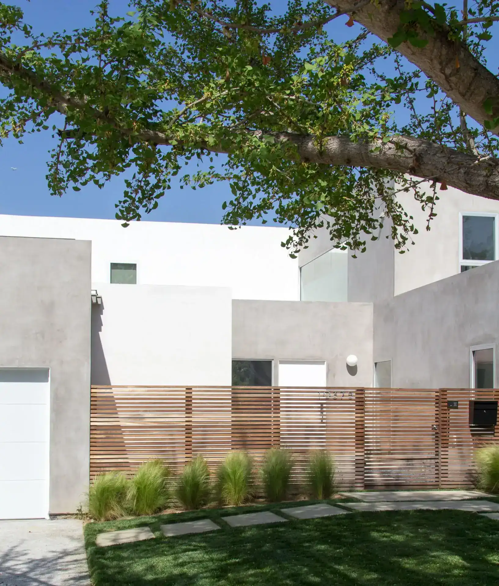Contemporary hillside residence with sleek stucco finishes and modern indoor-outdoor living spaces.