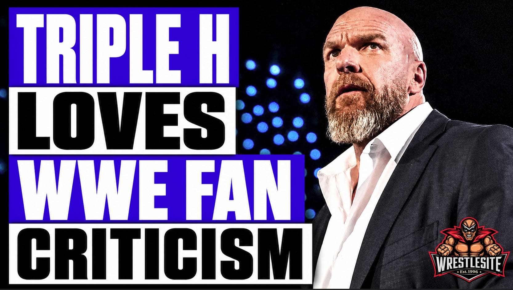 Triple H speaks into a microphone during a live WWE press conference event