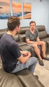 male therapist sitting with a male client