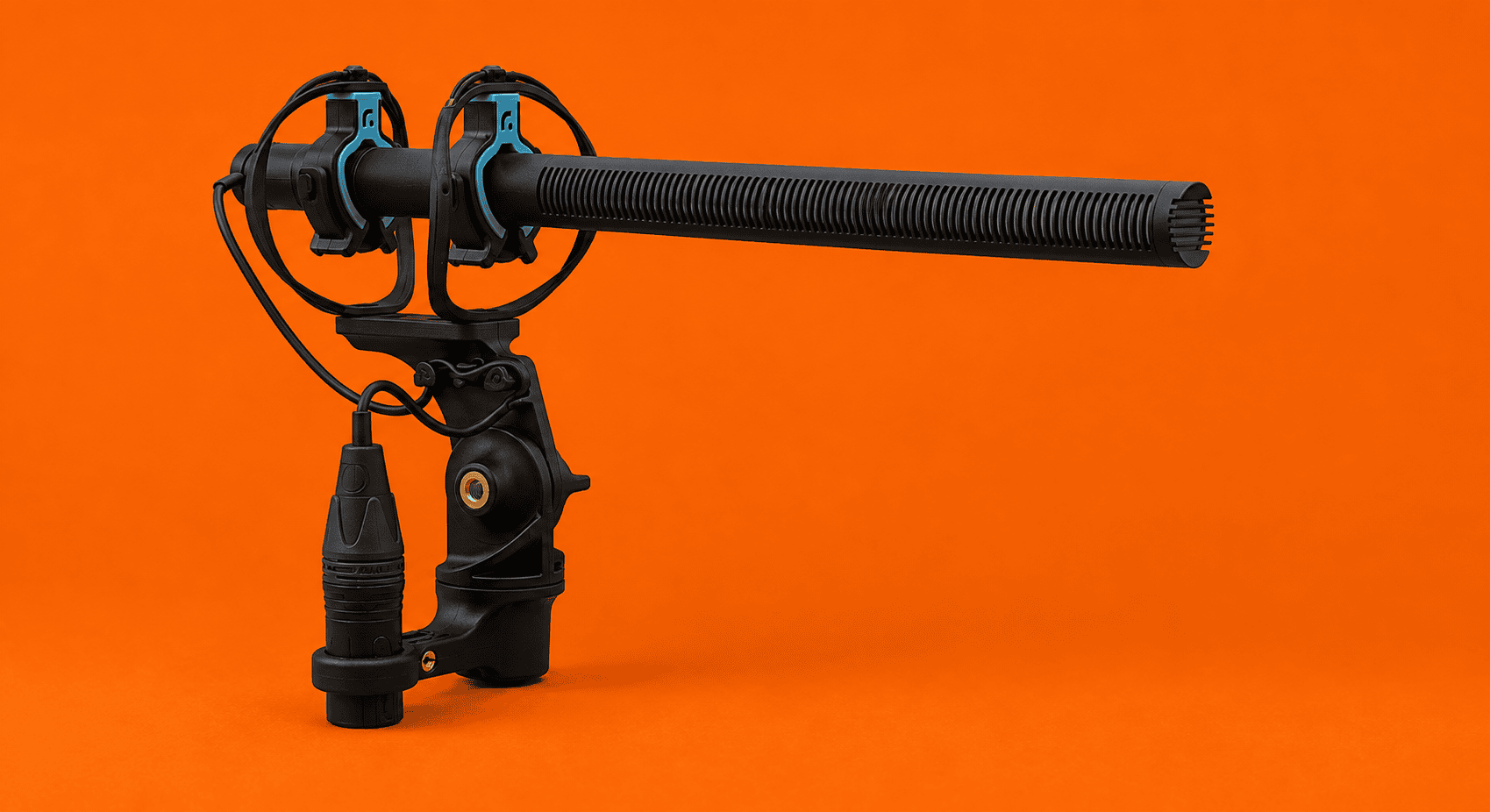 Shock mount for shotgun microphone with blue accents and XLR cable on orange background
