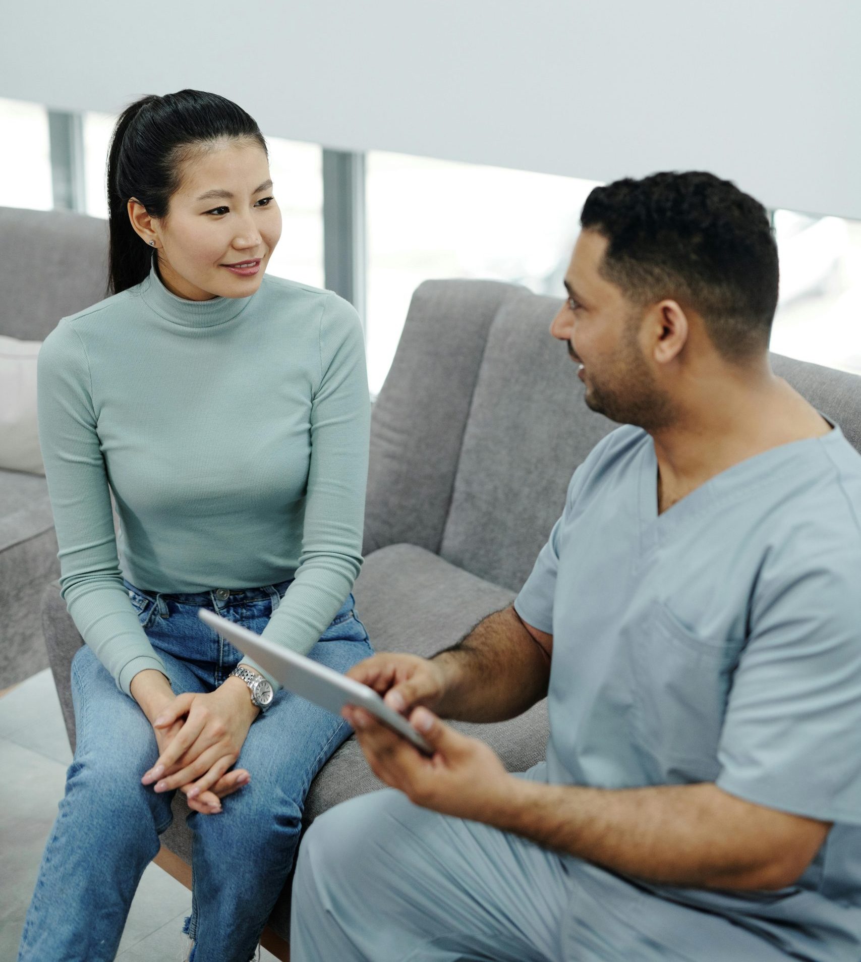 A physiotherapist assisting a patient with stretching exercises indoors.