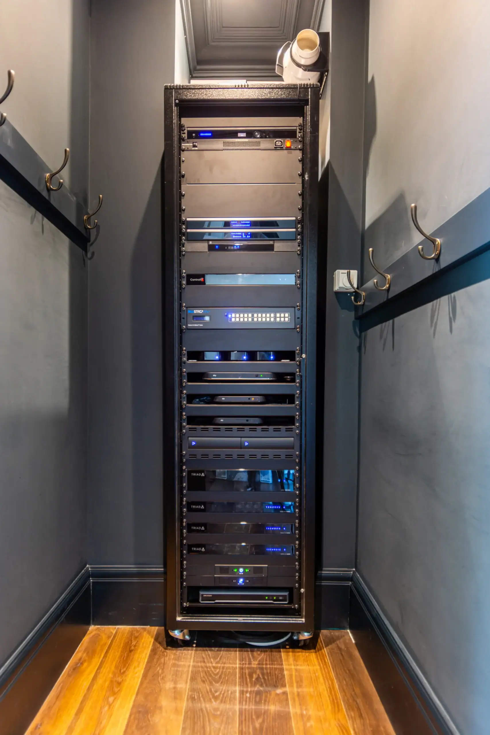Tall AV and network equipment rack installed in a narrow utility room