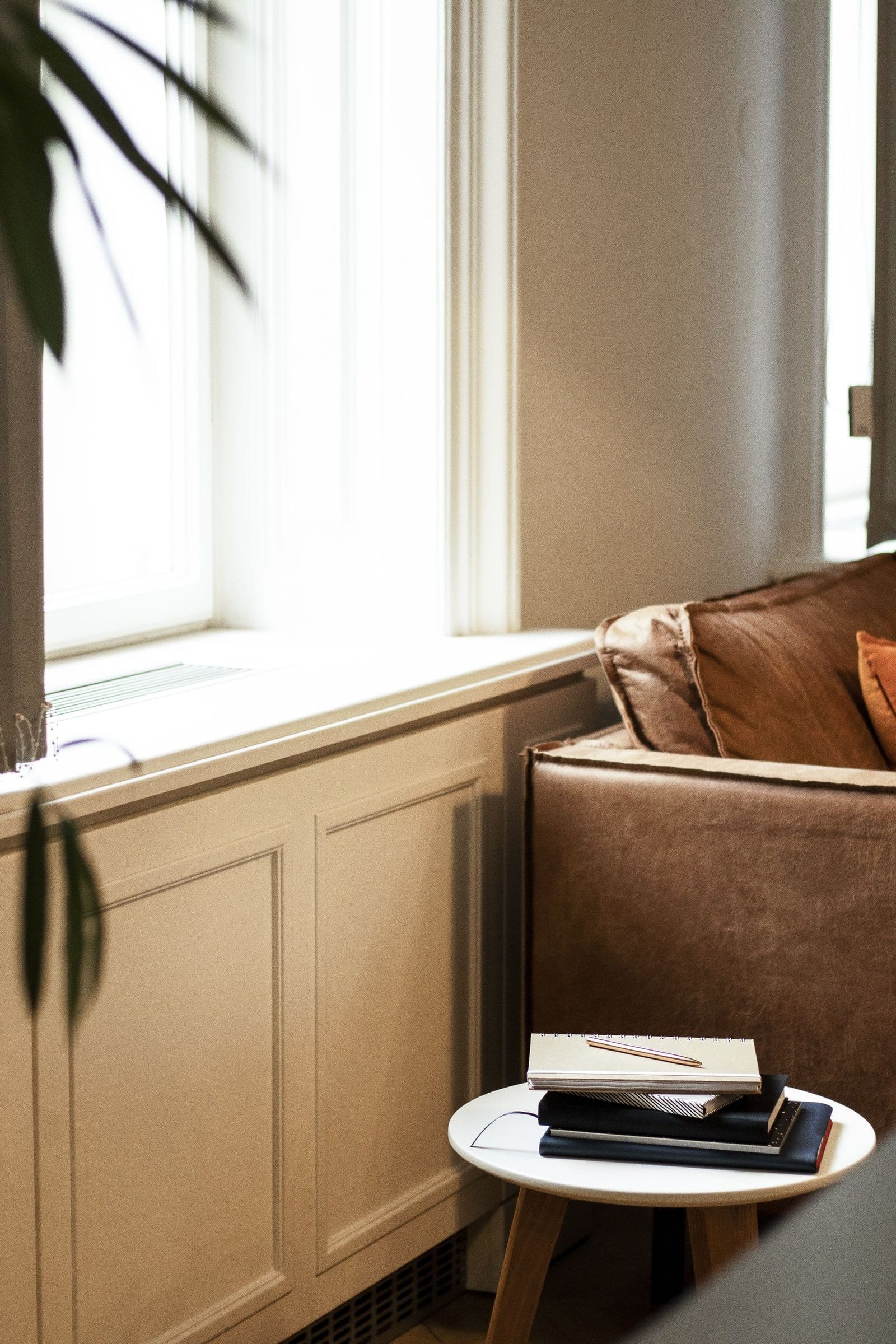 A way to rest without feeling guilty in a serene living room interior featuring a cozy sofa and a small coffee table by the window.