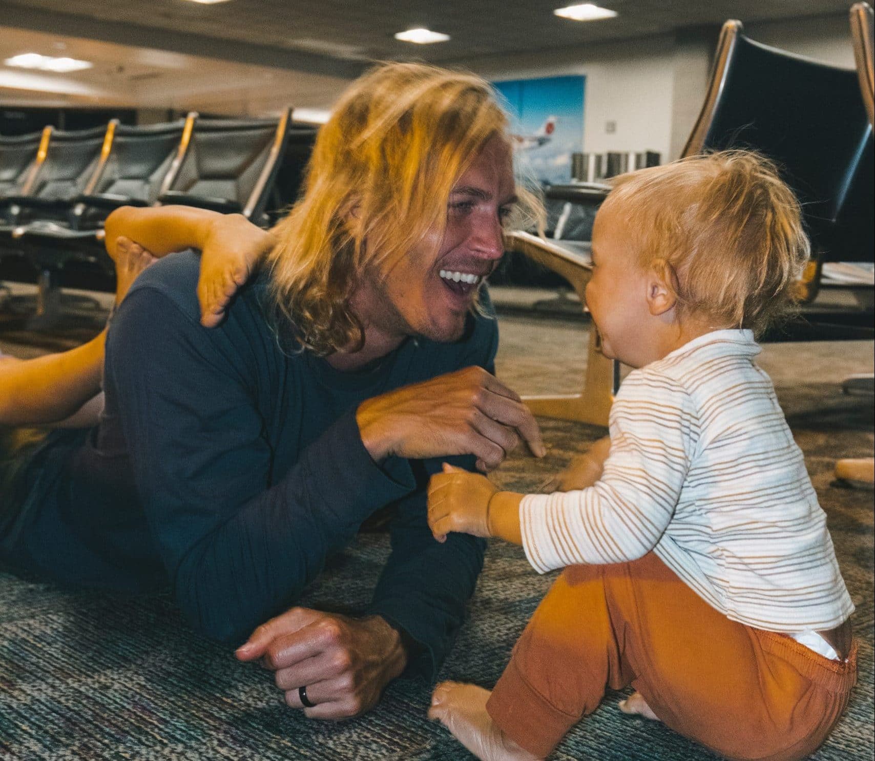 Man and kids laying on the floor of an airport