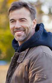 Smiling man with straight white teeth after emergency dentist