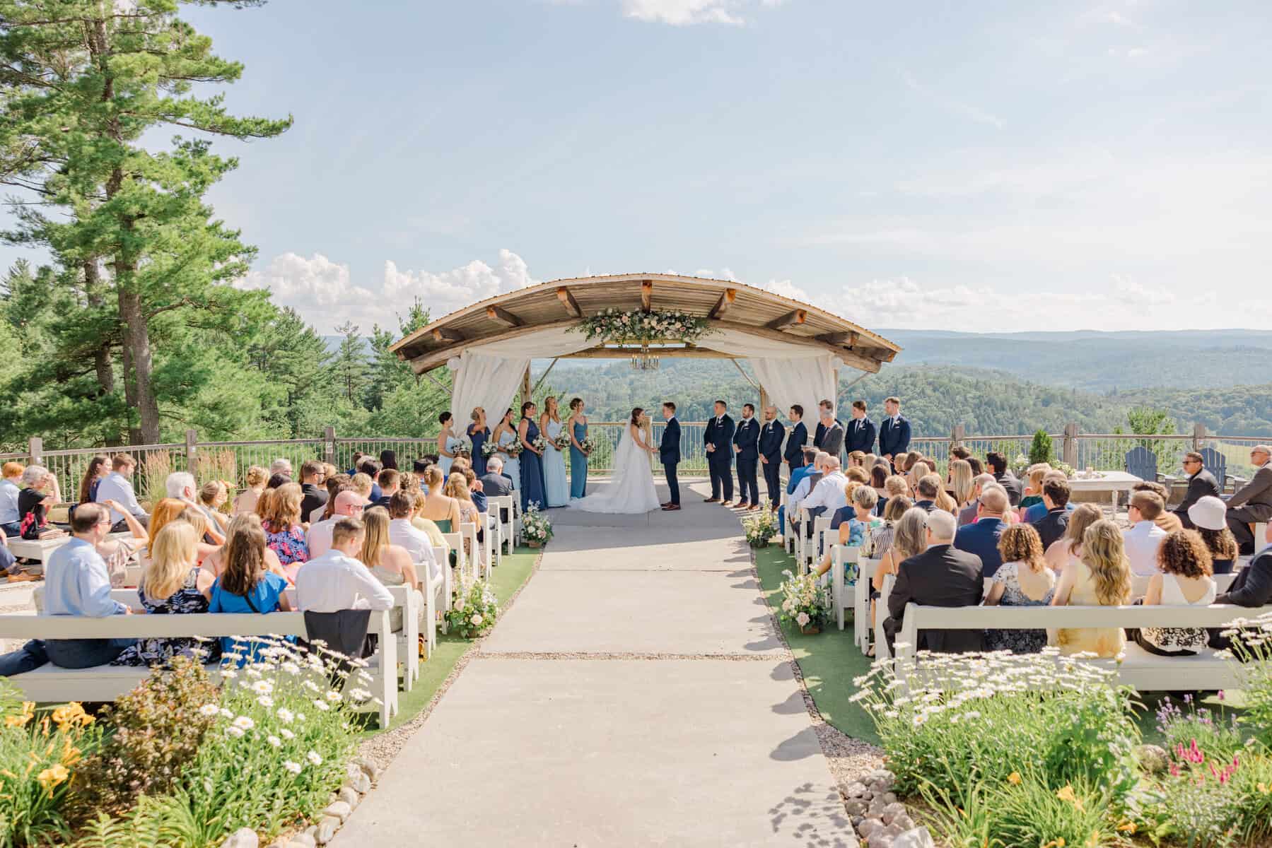 Wedding ceremony at Le Belvédère with scenic mountain views and guests seated outdoors.