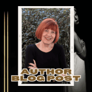 A portrait of a woman with vibrant red hair smiling warmly, dressed in a black top. She is standing outdoors with a backdrop of dense, green foliage. Her arms are crossed, and she wears a distinctive bracelet with key charms.