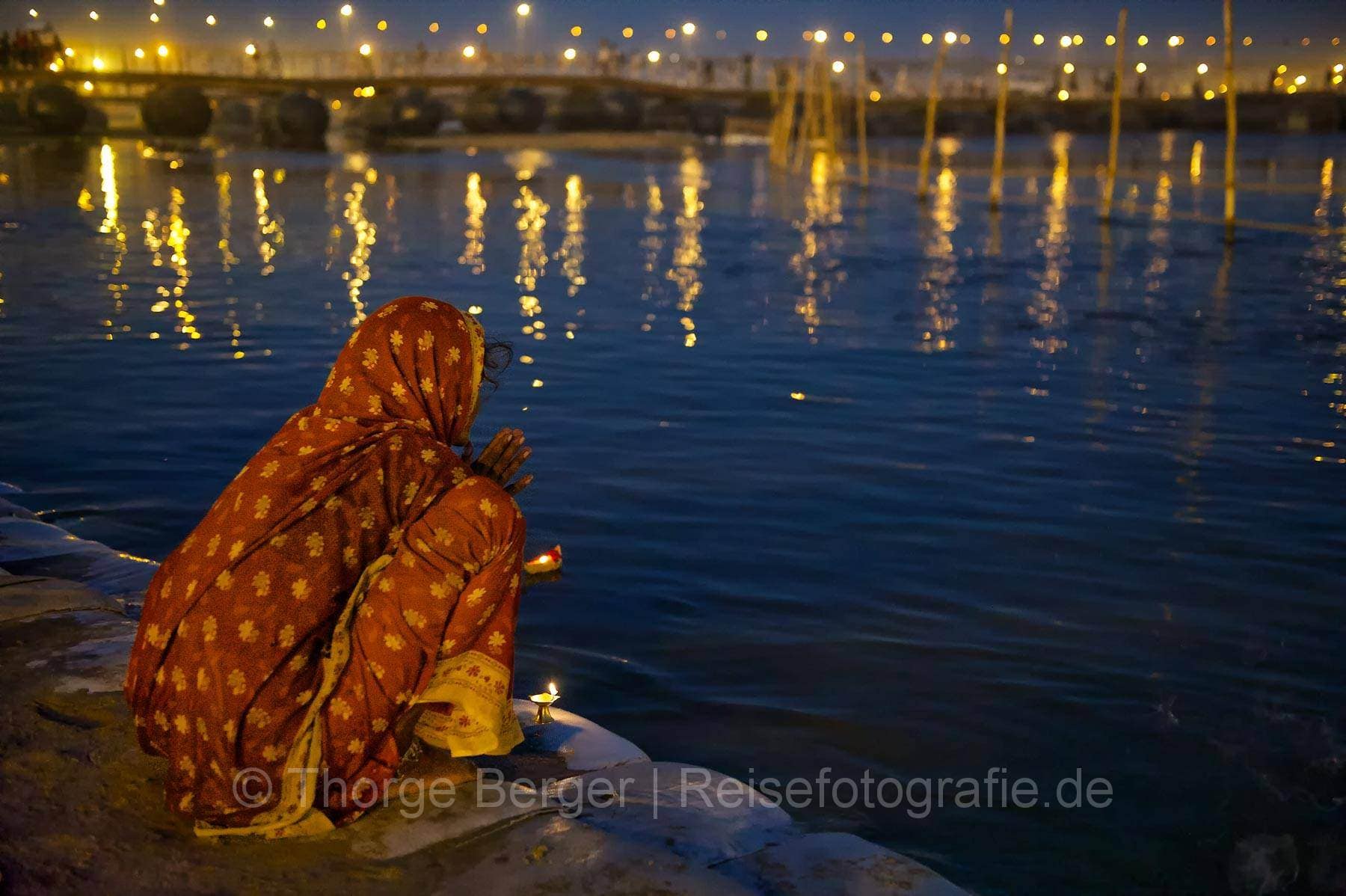 Betende Frau am Ganges auf der Kumbh Mela 2013 in Allahabad