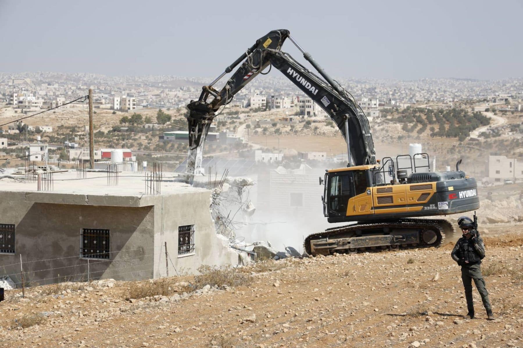 Demolition taking place with HD Hyundai machinery near the town of Yatta in the southern West Bank © B'Tselem