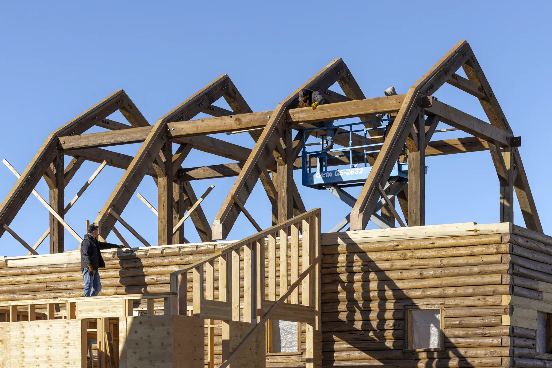 Reclaimed hand-hewn truss being raised at a private residence