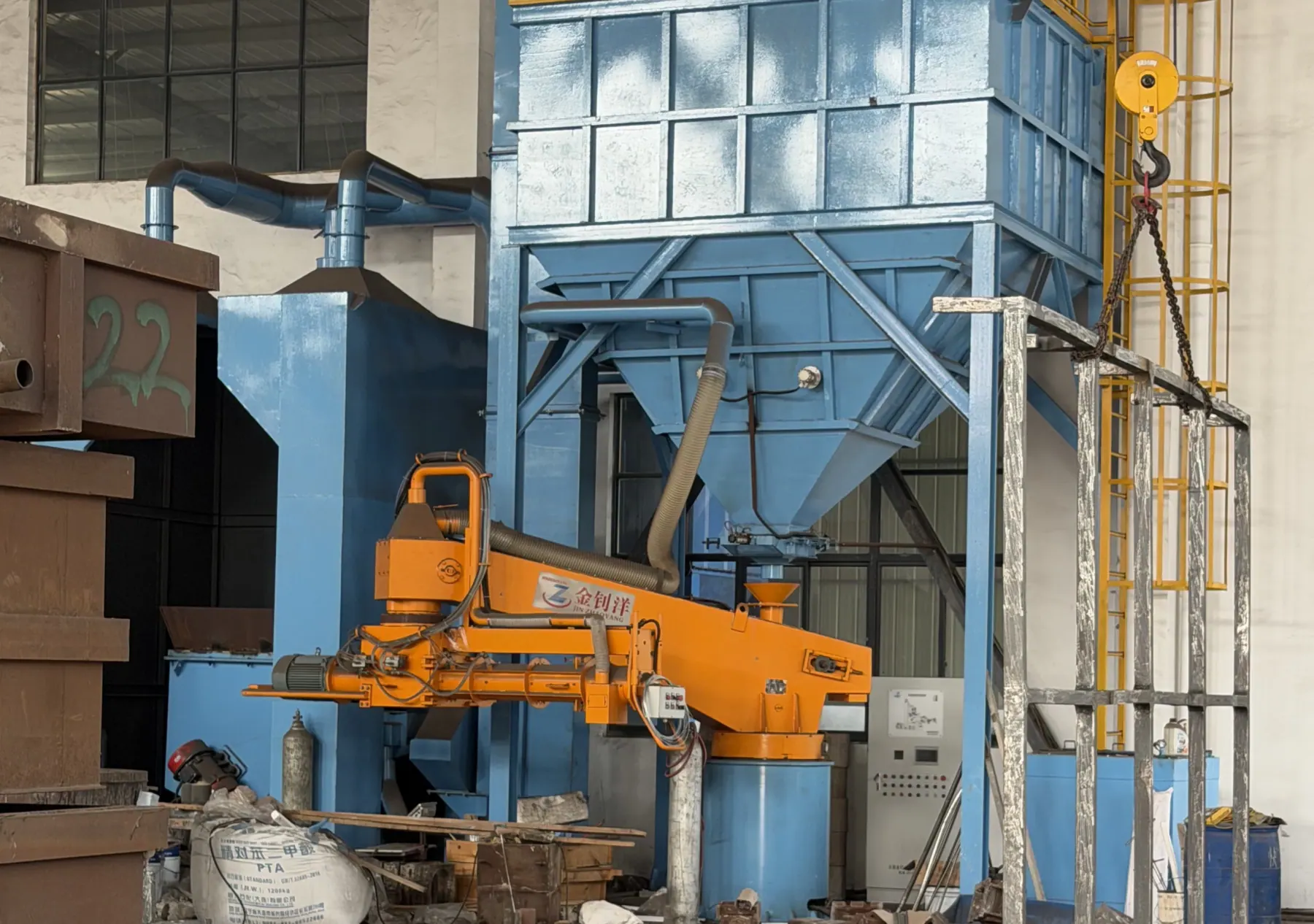 Blue foundry equipment with orange production machinery and steel access platforms