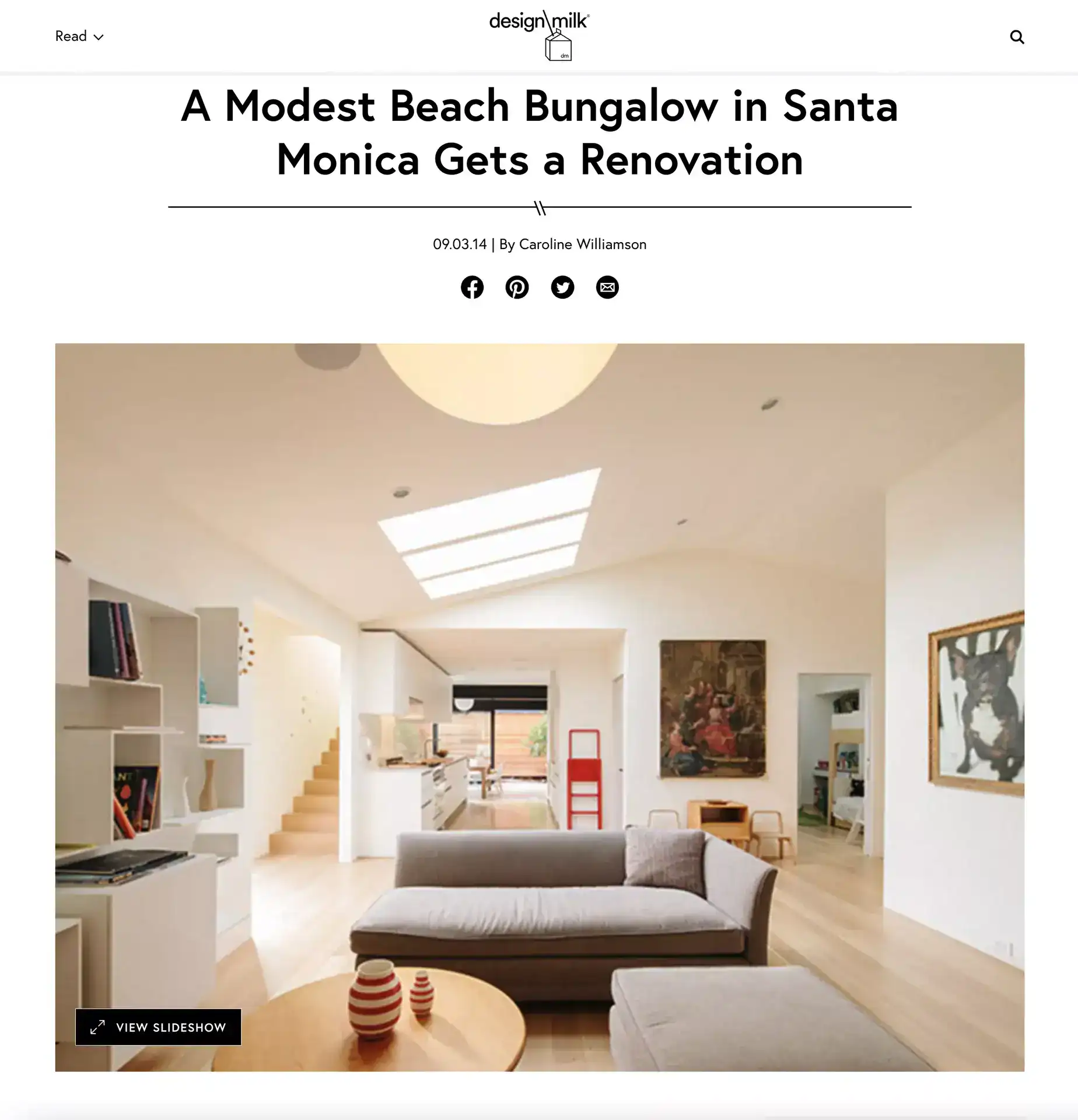Modern white interior living room with built-in shelves, minimalist furniture, and natural light.