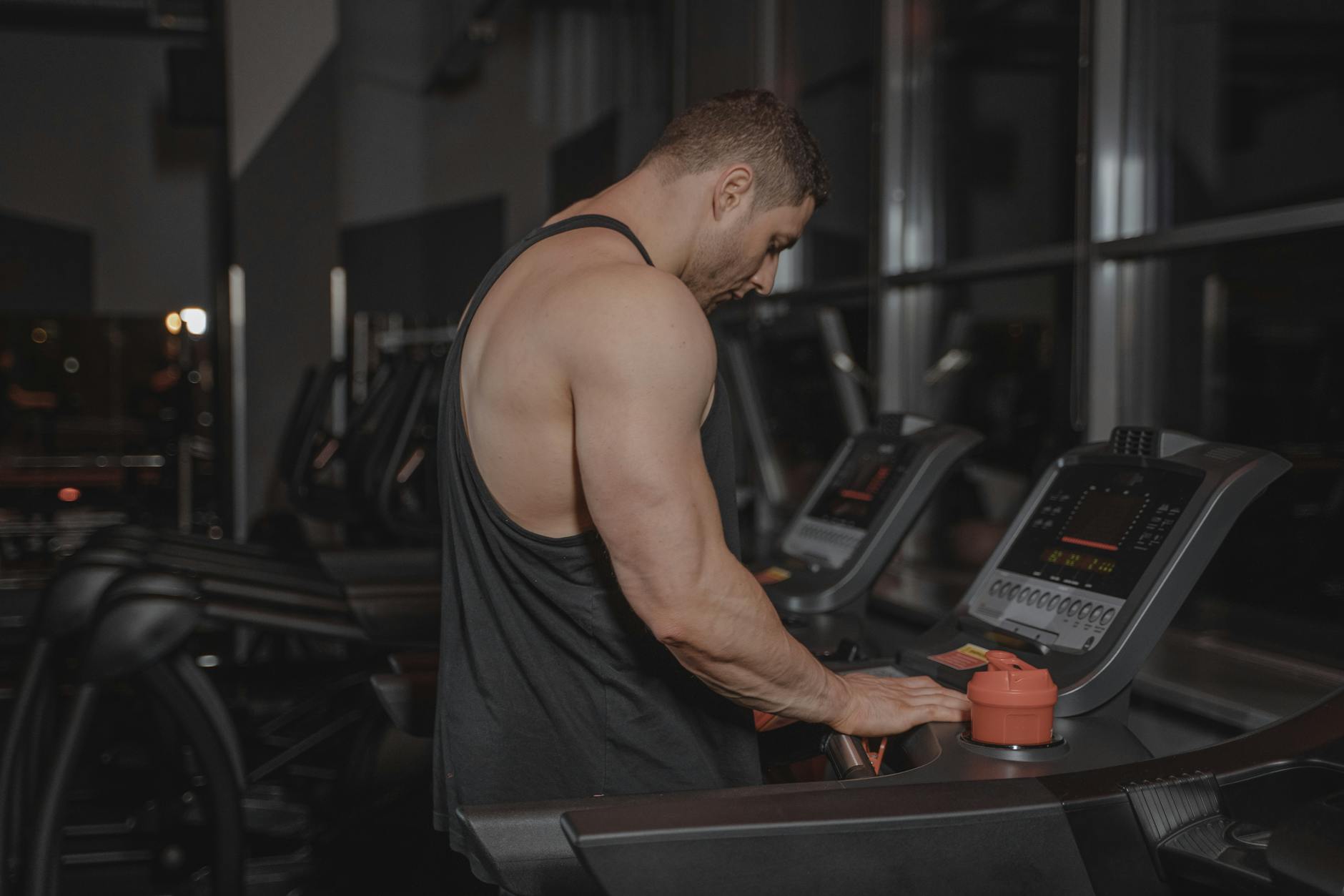 man in black tank top using a treadmill