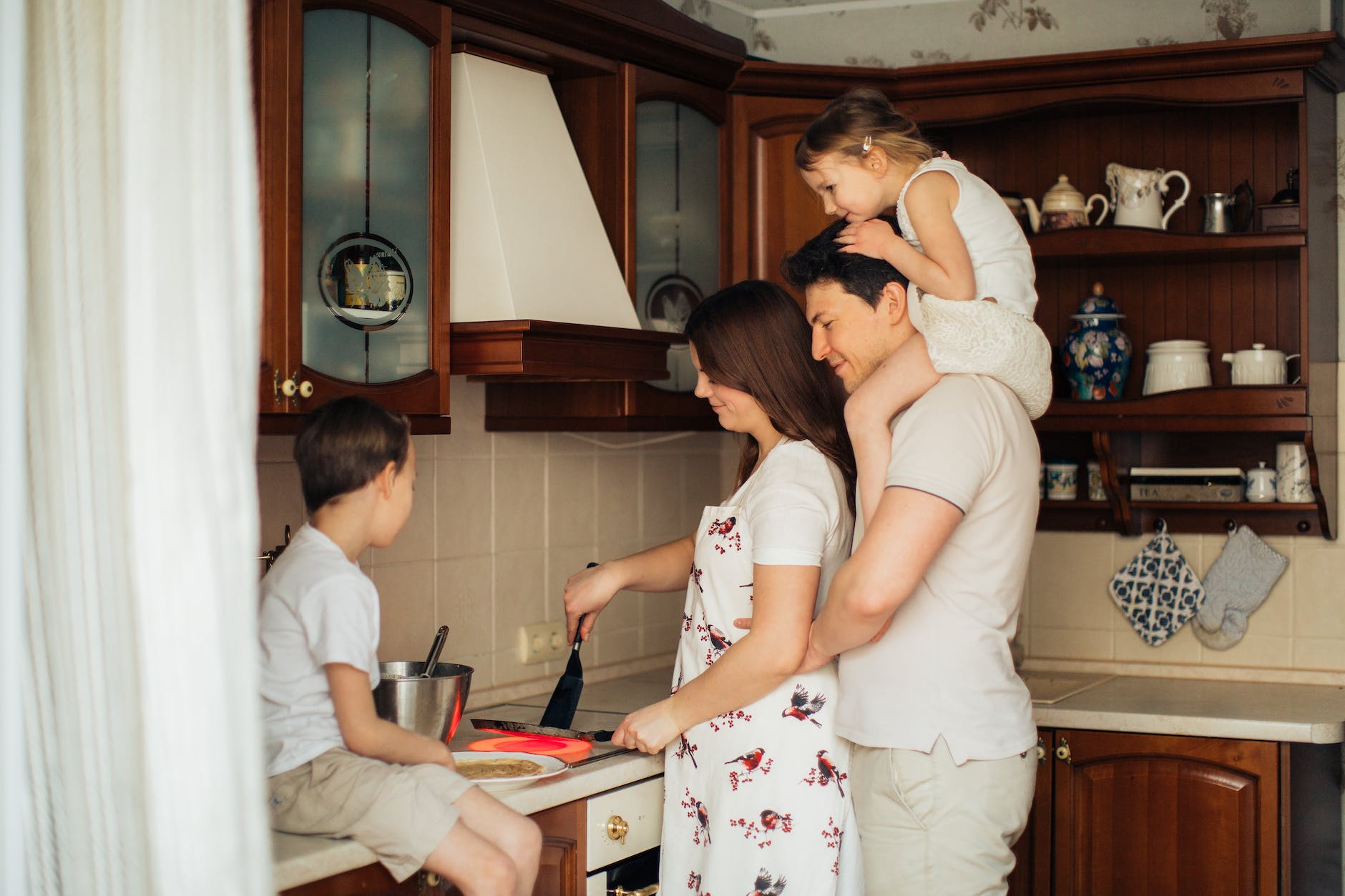 photo of woman cooking near her family