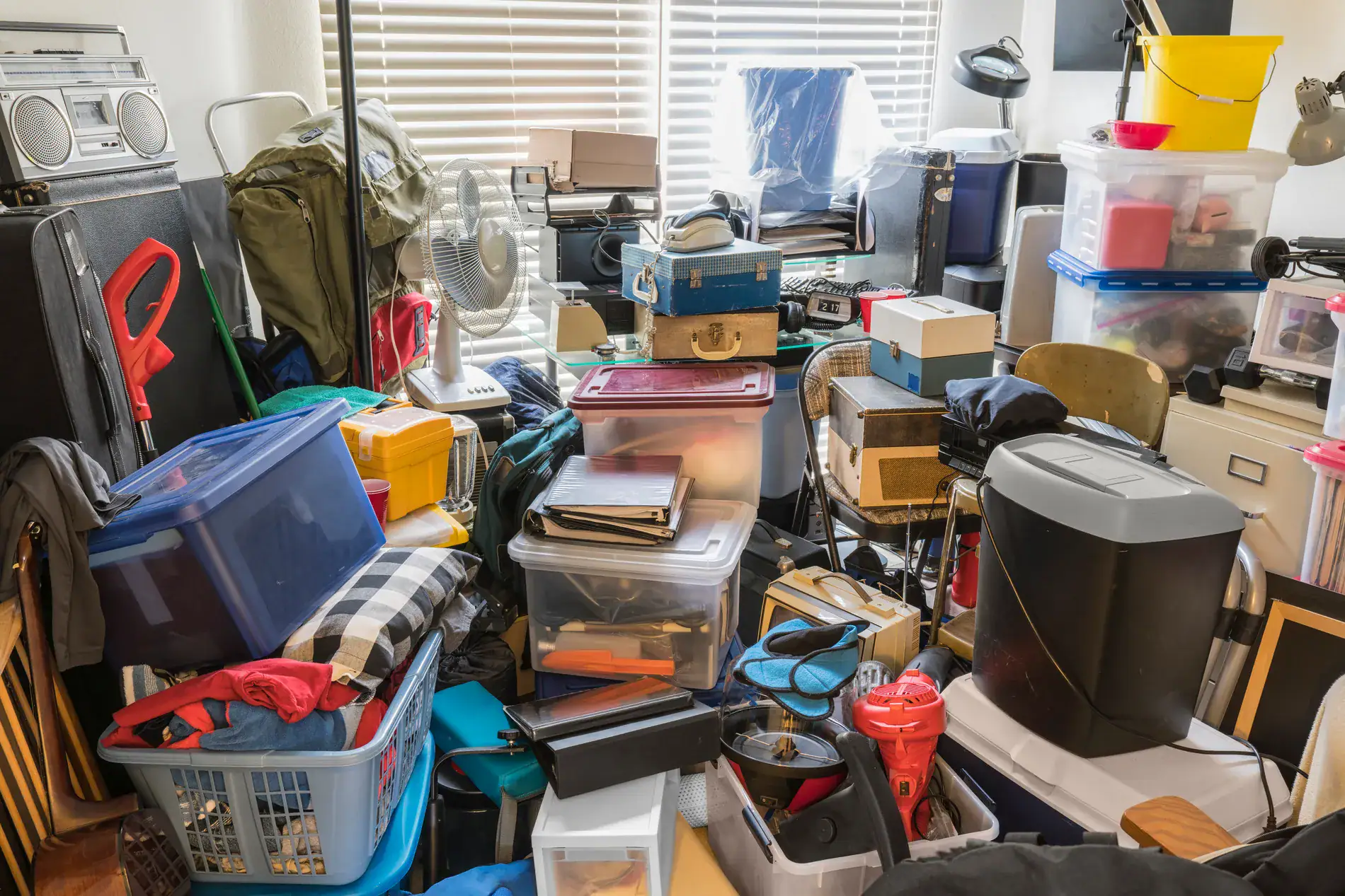 A crowded storage room filled with boxes and bins, demonstrating the need for New Year’s storage organization.