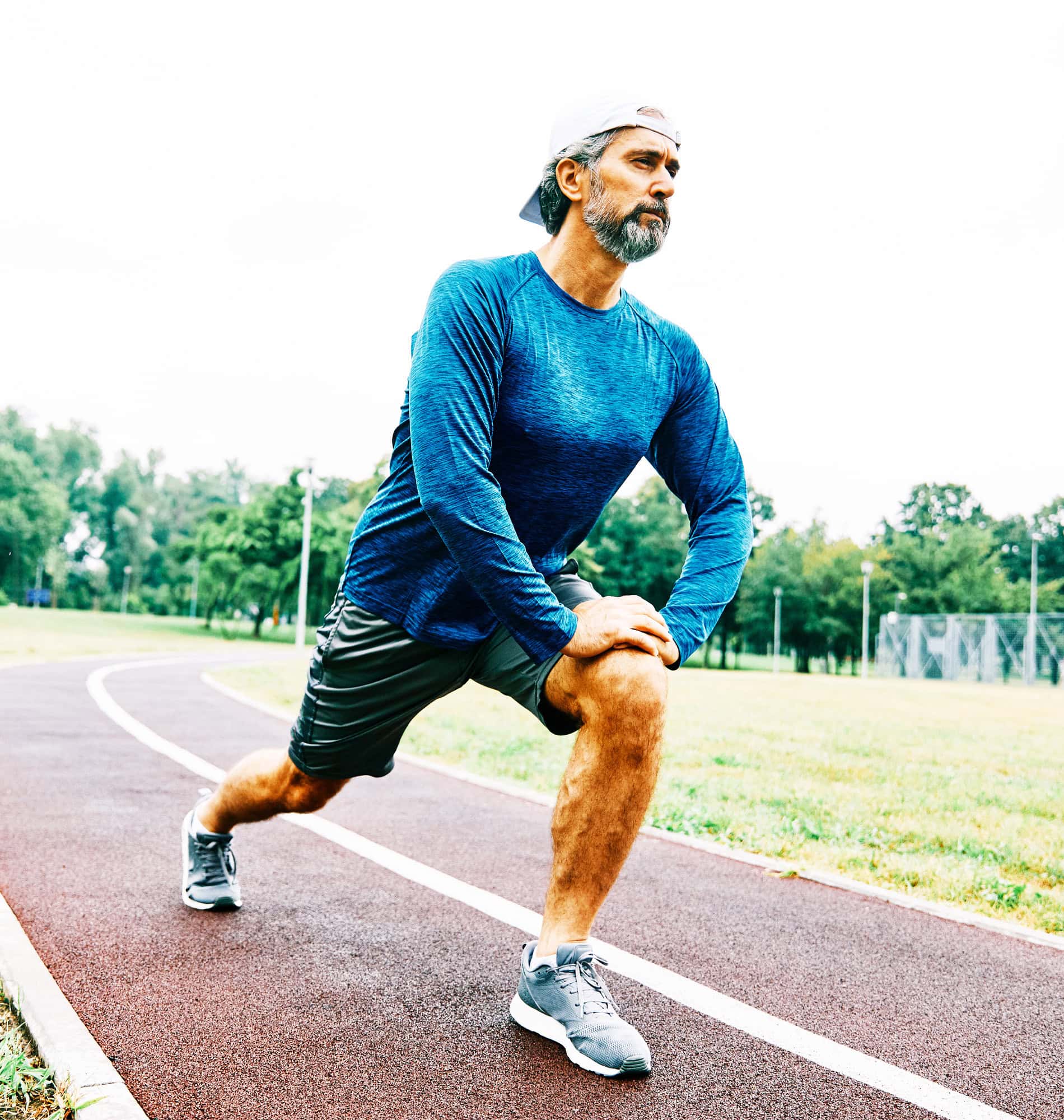 Man stretching on a running track to support joint pain relief and mobility with treatment at BionwoRx in Carmel, Indiana