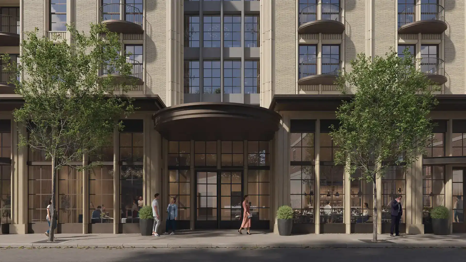 Modern mixed-use building with large glass storefronts and residential balconies, featuring beige brick facade and black window frames.