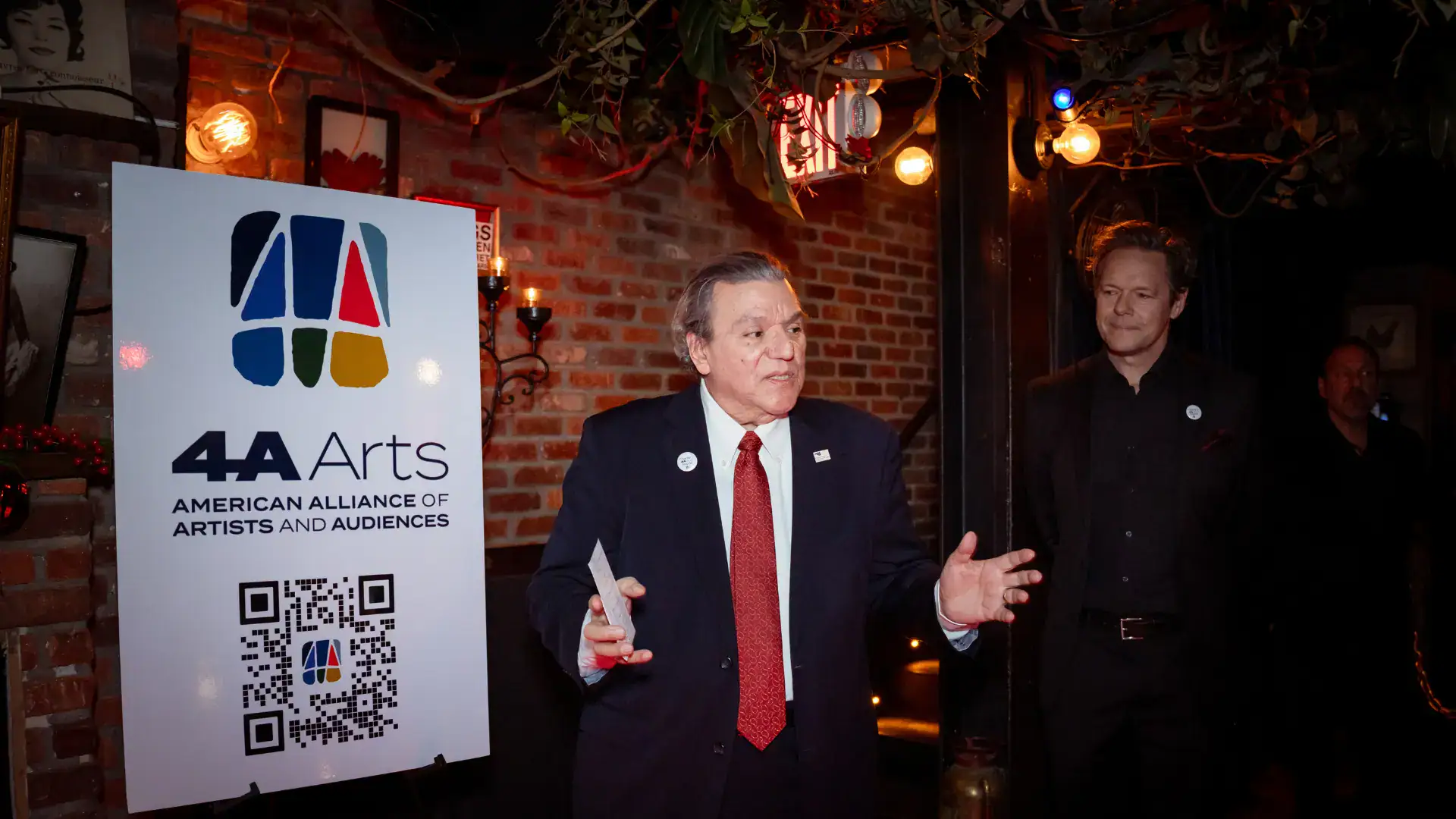 Board Chair Luis Cancel addresses the guests about Charlie Reinhart's vision for arts advocacy as Executive Director Gavin Lodge looks on