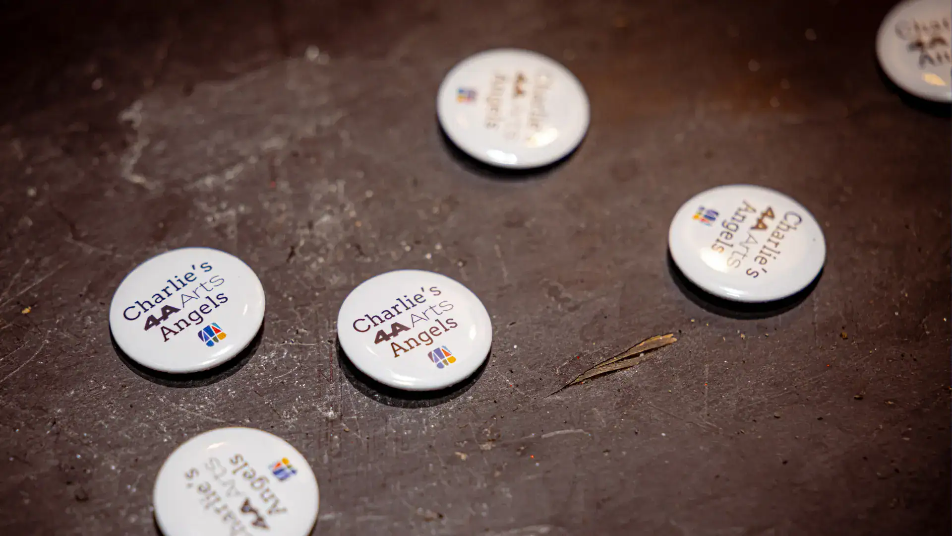 Five pin buttons that say "Charlie's Angels"