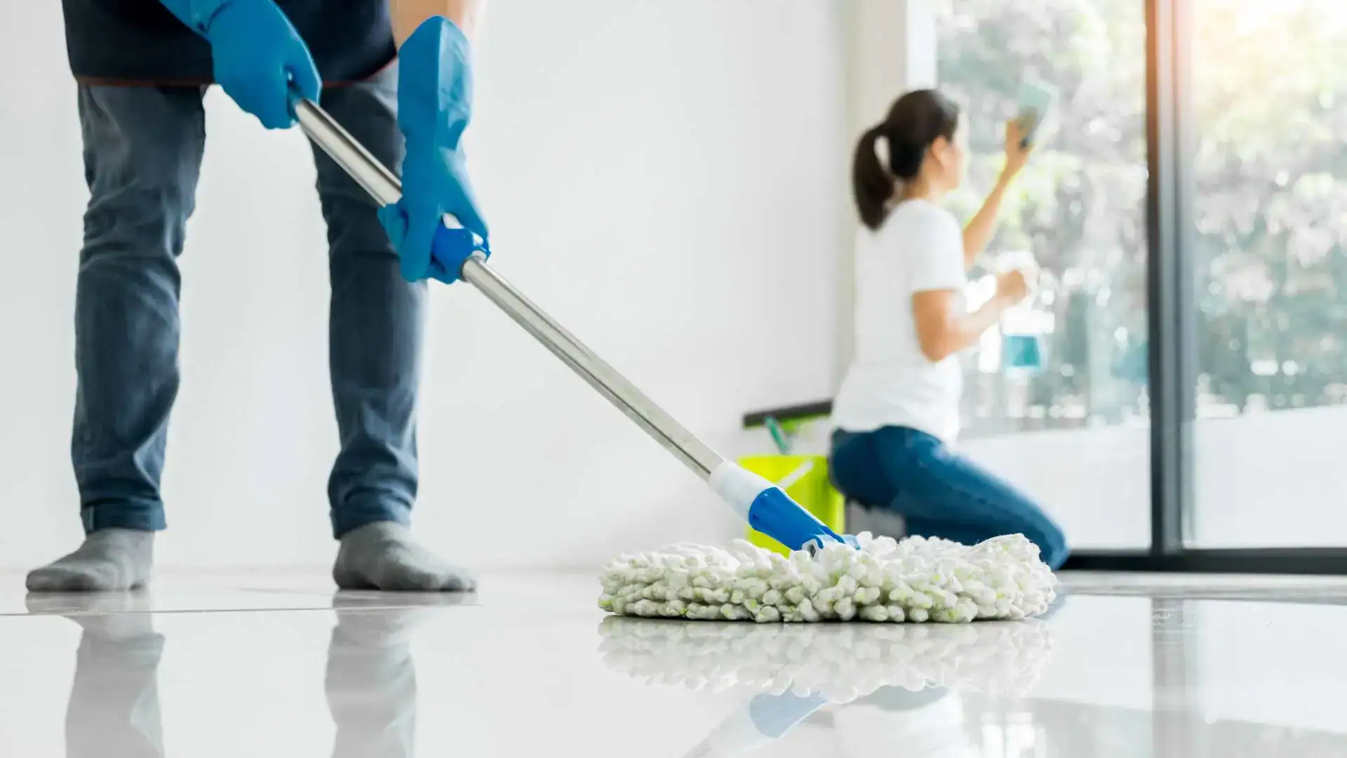 Pessoas limpando a casa com esfregão e spray de limpeza