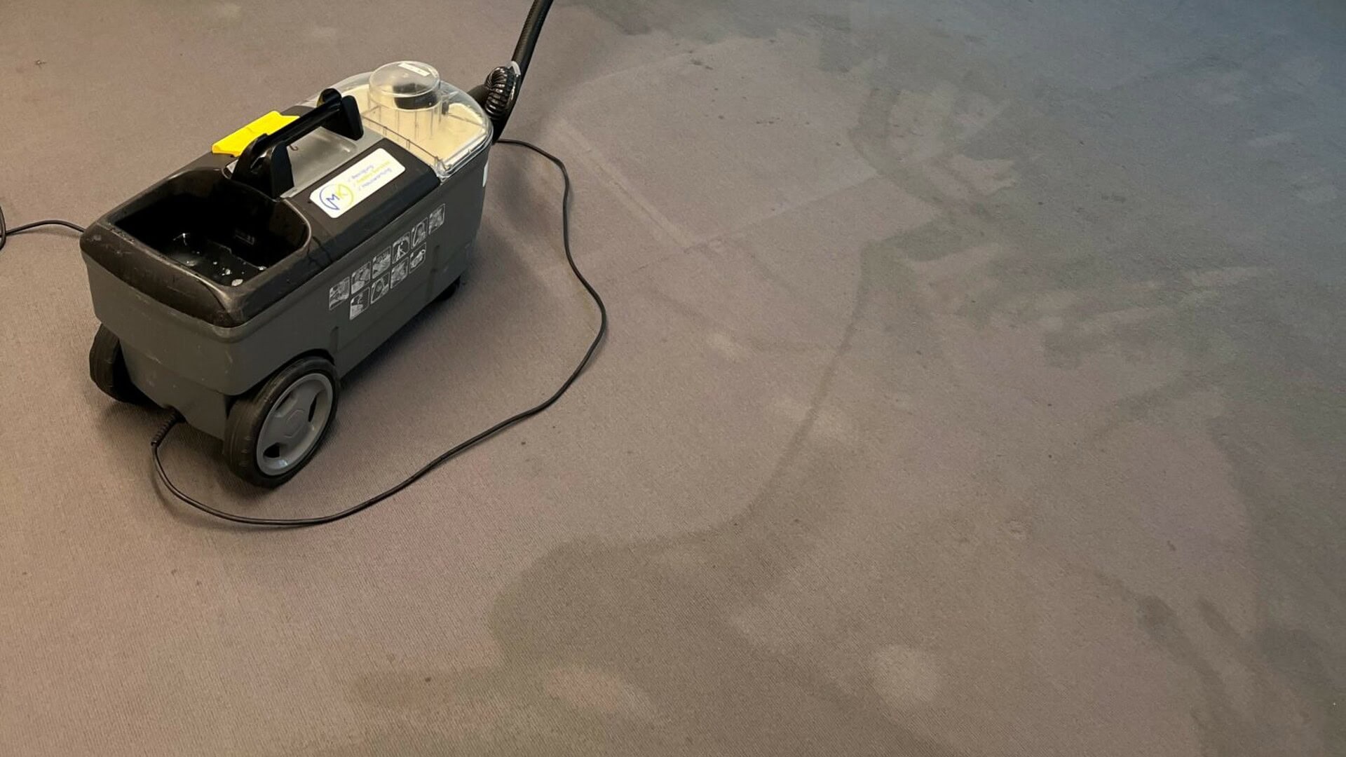 Mitarbeiter mit Staubsauger bei der Teppichreinigung