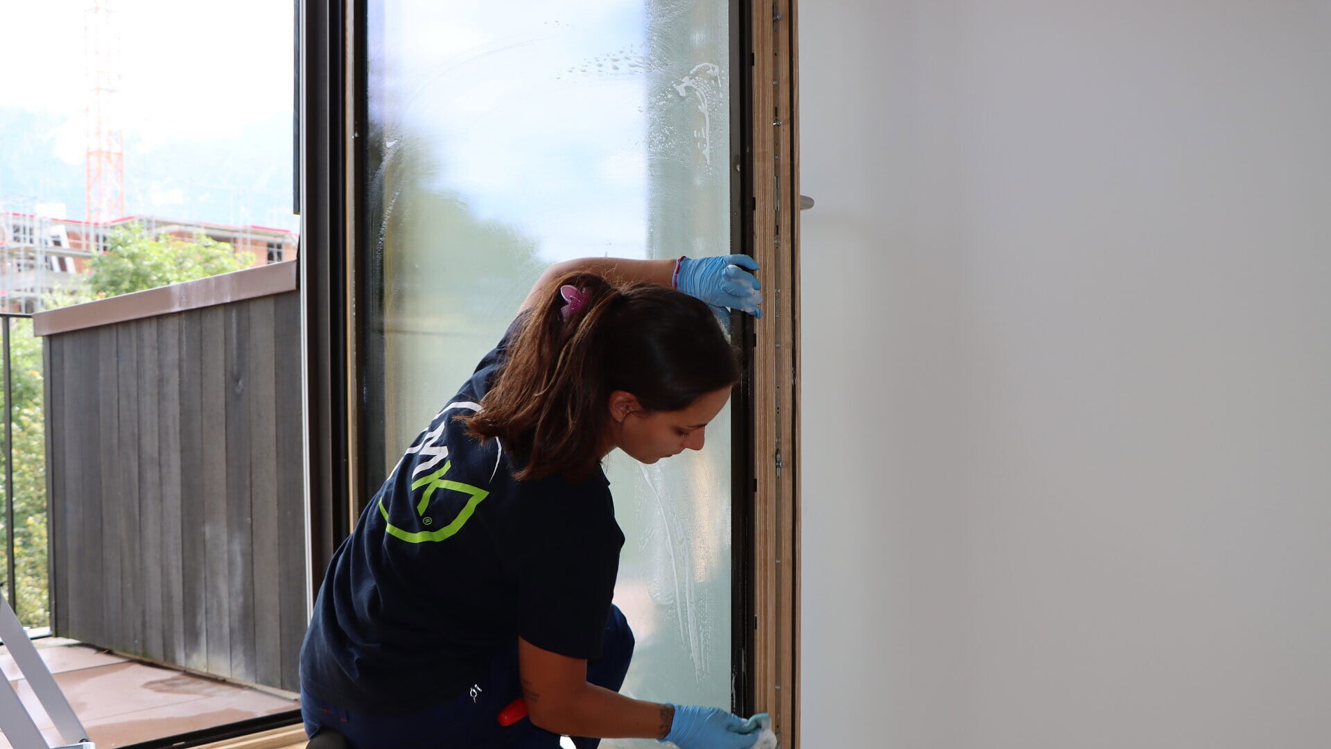 Umzugsreinigung Mitarbeiterin beim Fenster putzen