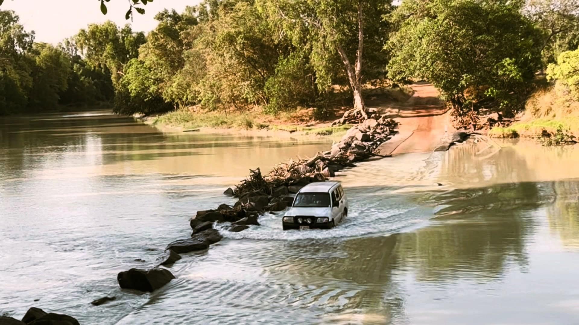 car crossing half submerged road on the route between kakadu and arnhem land