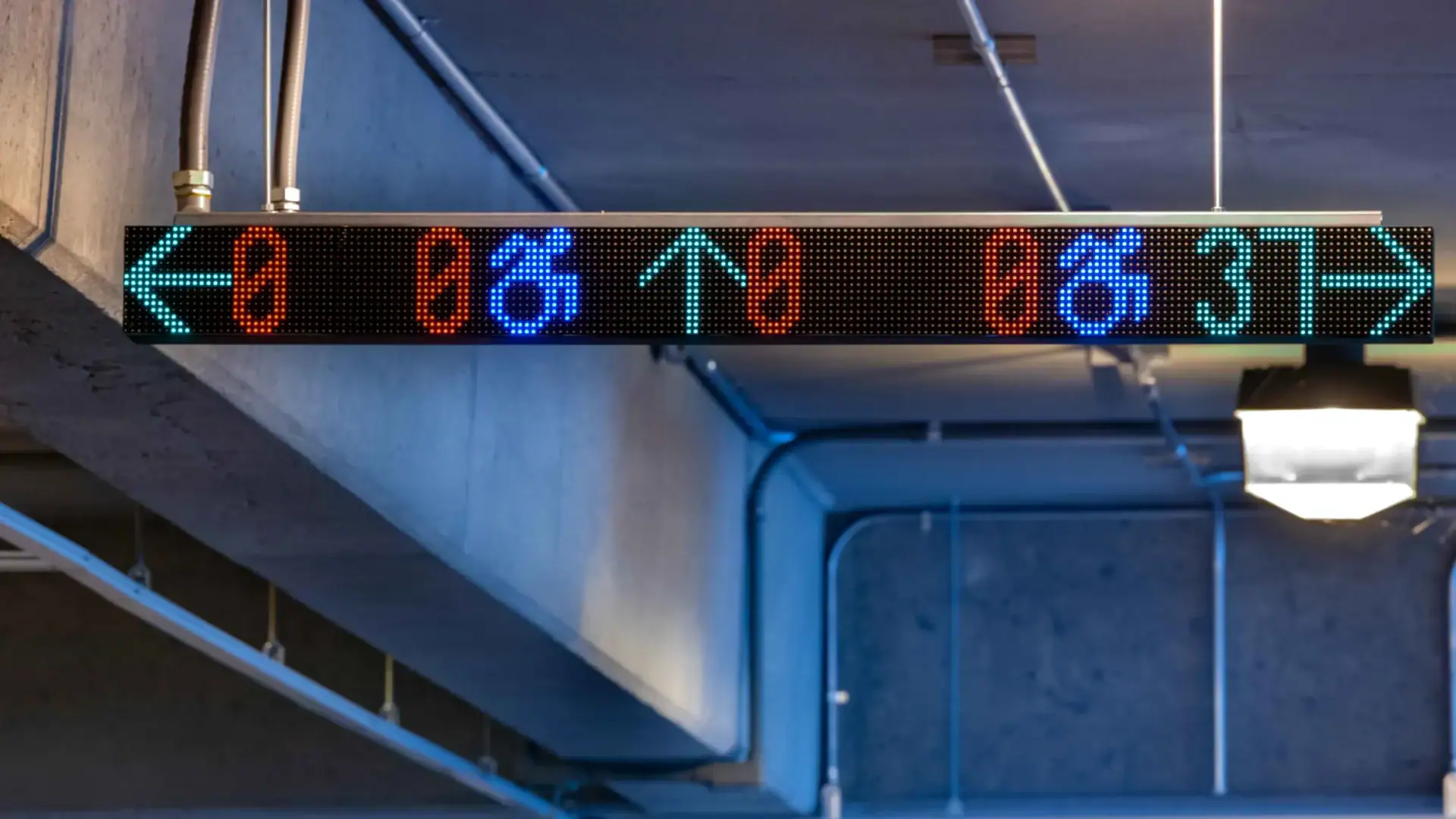 A car driving in a parking garage under red M5 smart sensors and a VMS sign that reads "Full", both indicating the lack of available parking spaces.