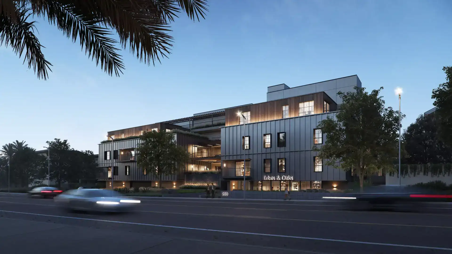 Contemporary multi-story building featuring clean lines, mixed materials like metal panels and wood accents, with illuminated windows and modern lighting.