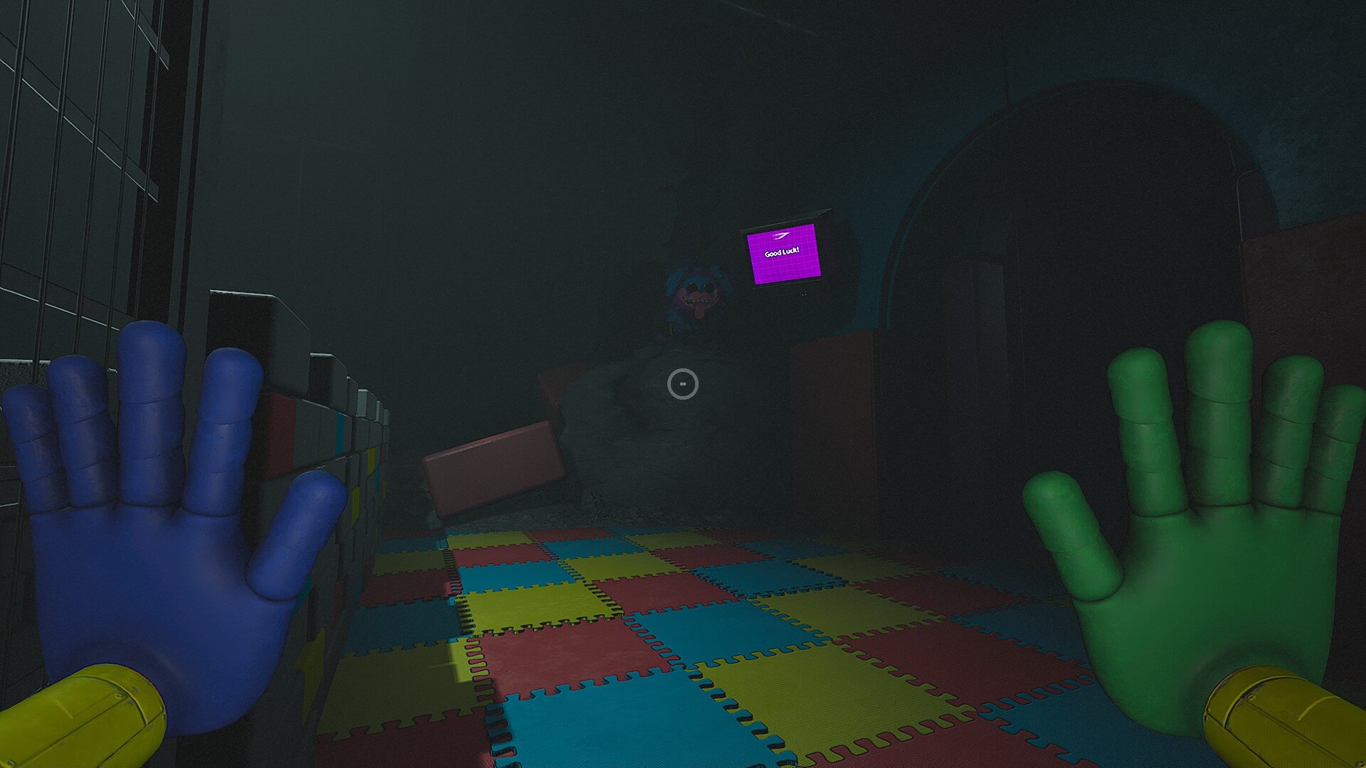 A first-person view in a dimly lit room with colorful floor tiles. Blue and green hands are visible in the foreground. A shadowy figure lurks in the back, creating a tense atmosphere.