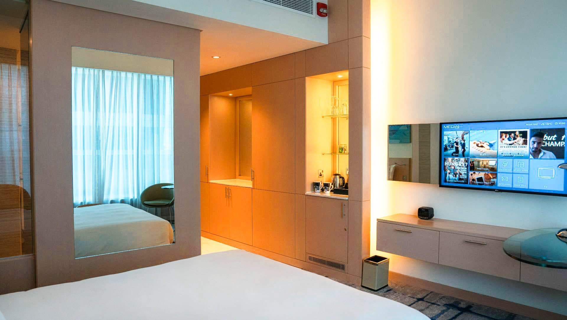 media-one-pod-room-header Media One Hotel room showing a tv, mirror and wardrobe space.