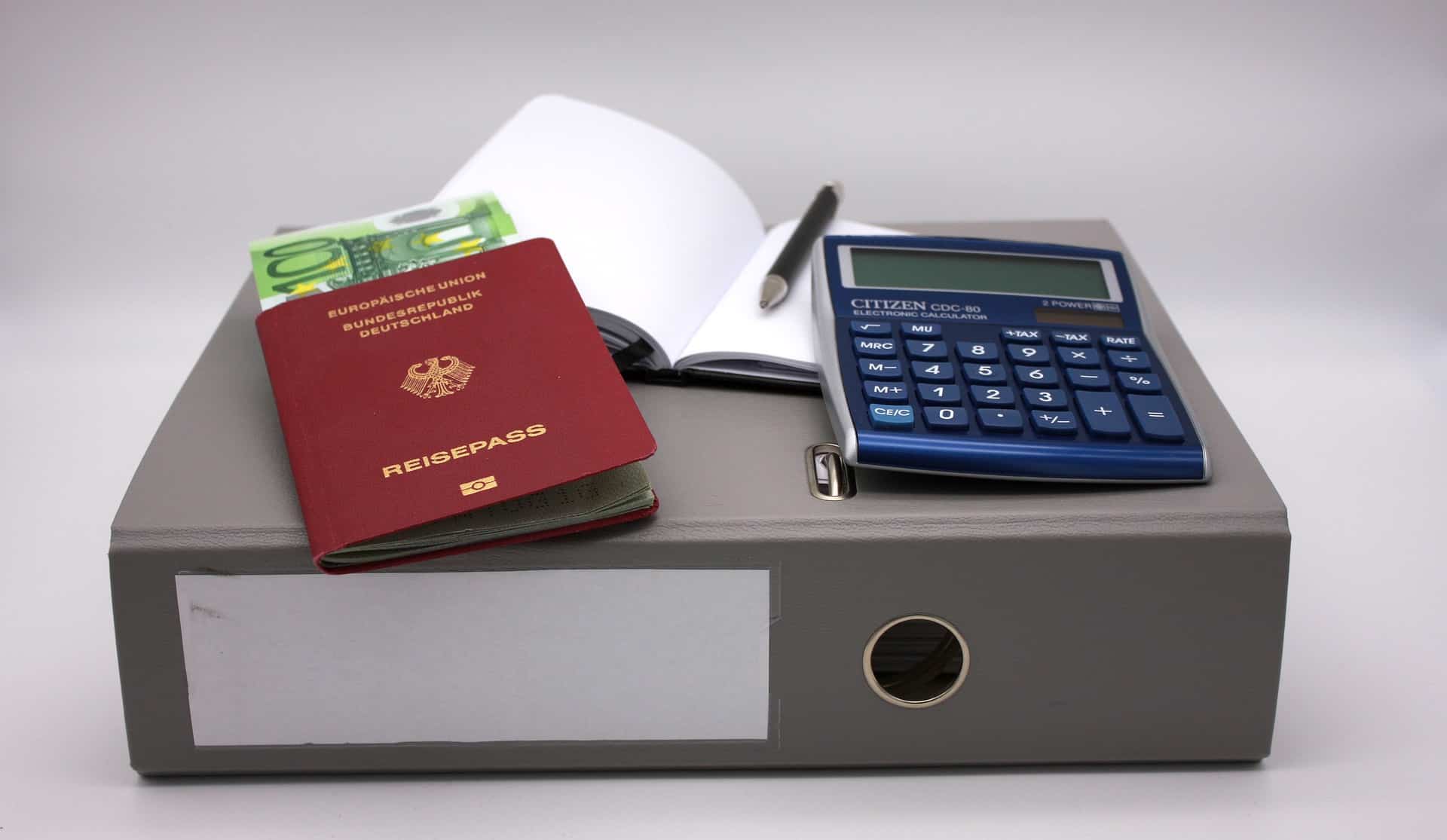 Binder with passeport, calculator and paper work. Family travel insurance.