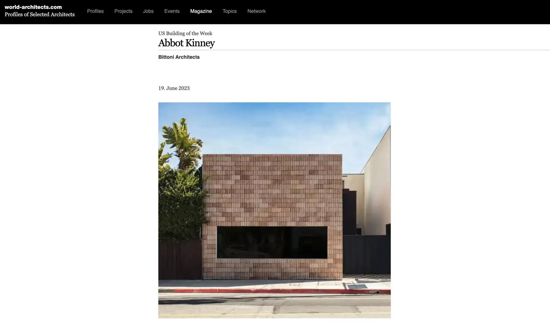 Contemporary building with a brick facade, minimalist design, rectangular form, and large black window.