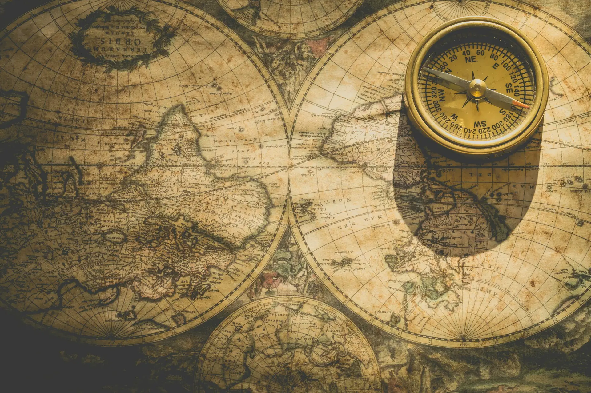 Une boussole posée sur une carte de navigation ancienne