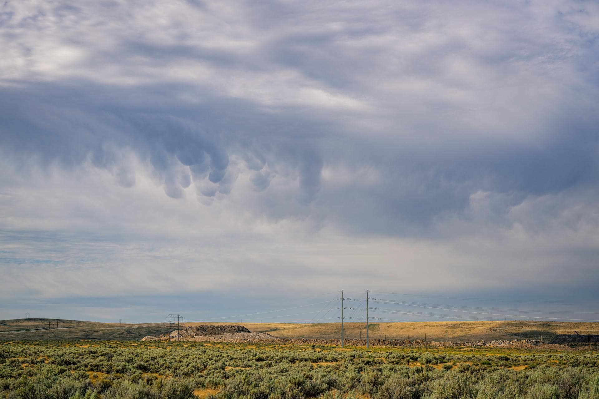 View of power lines above Boise with cloudy skies above