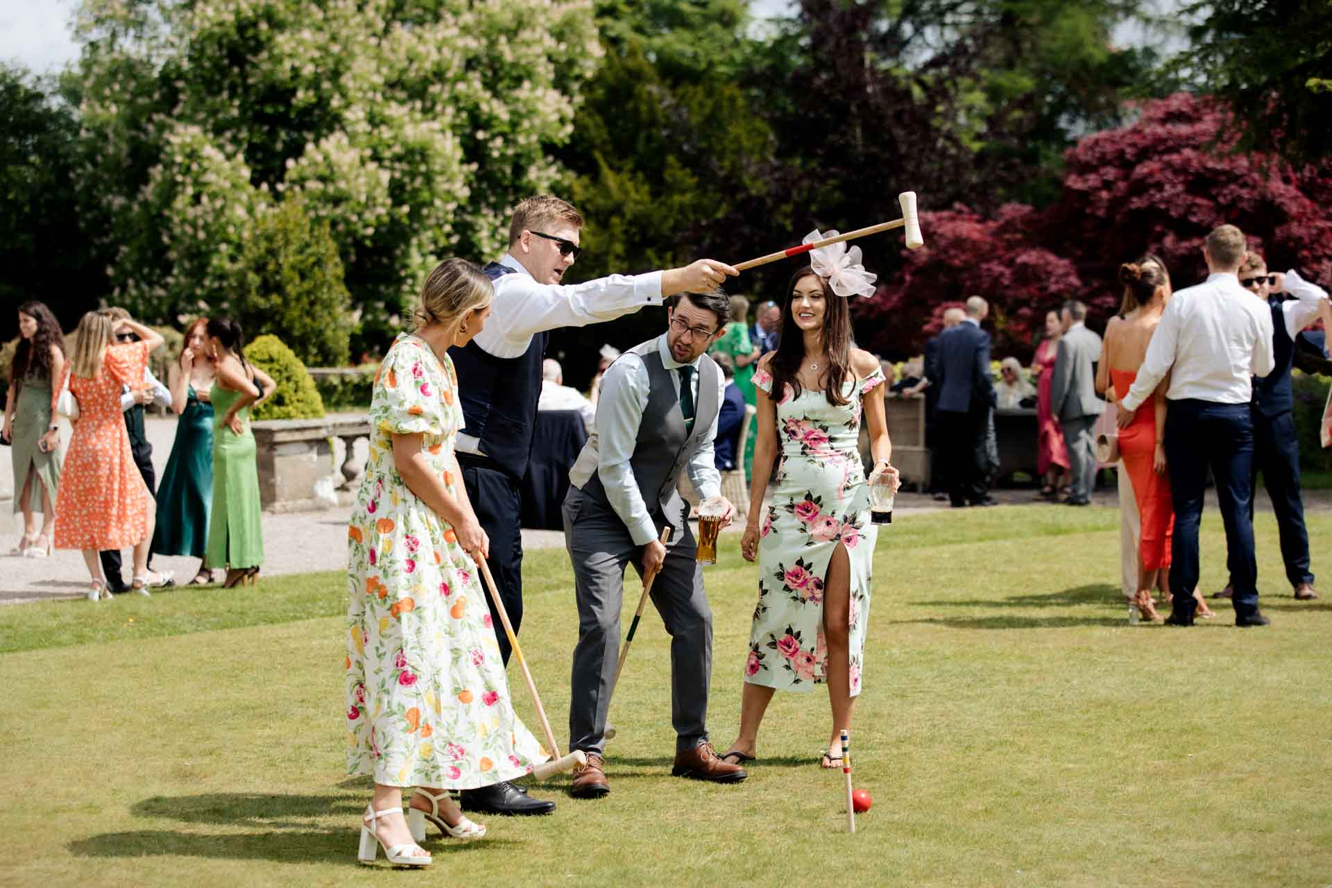 wedding guests in the grounds of eaves hall enjoying garden games