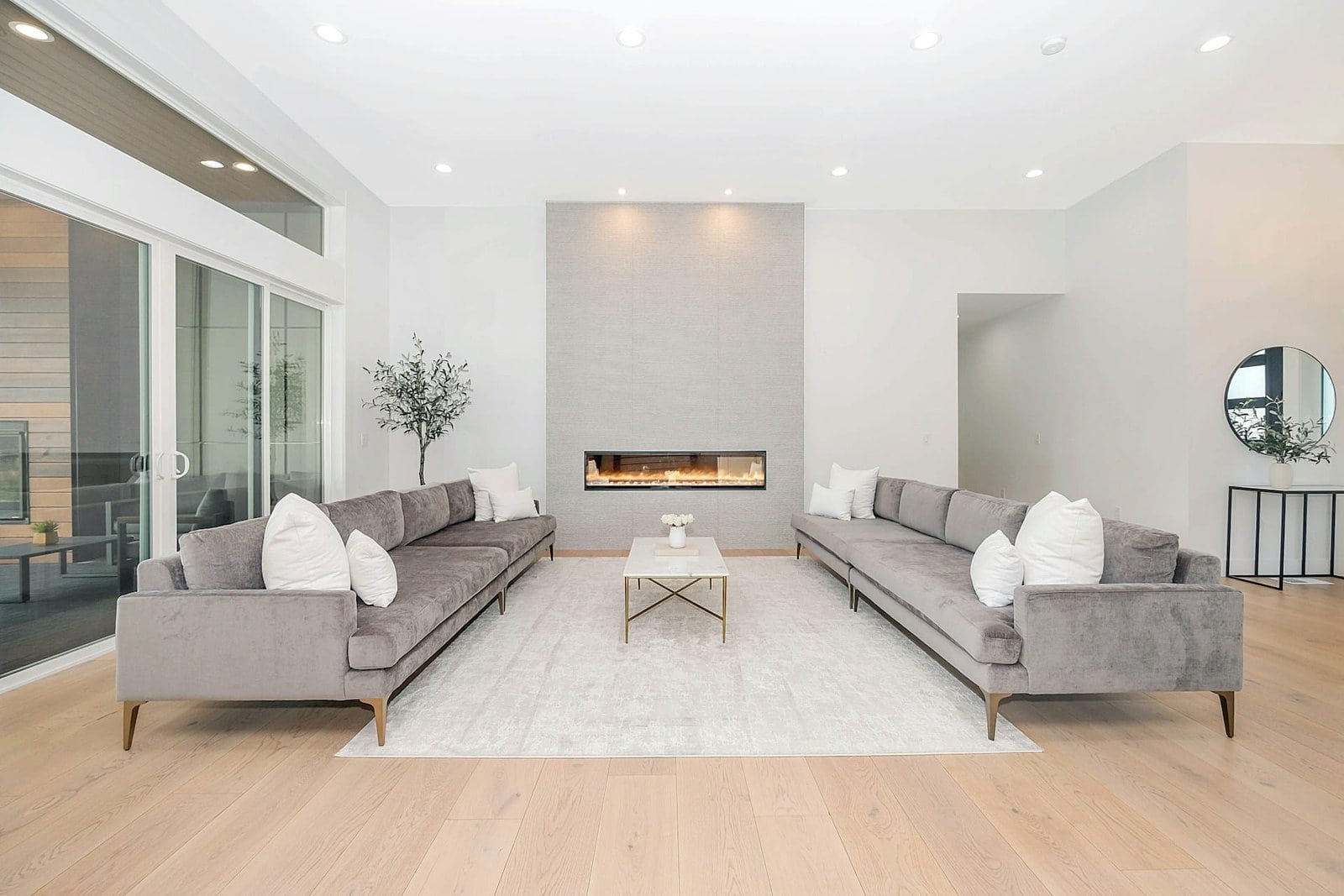 Modern living room renovation trends 2026 featuring vaulted ceilings, skylights, fireplace, and open floor design.