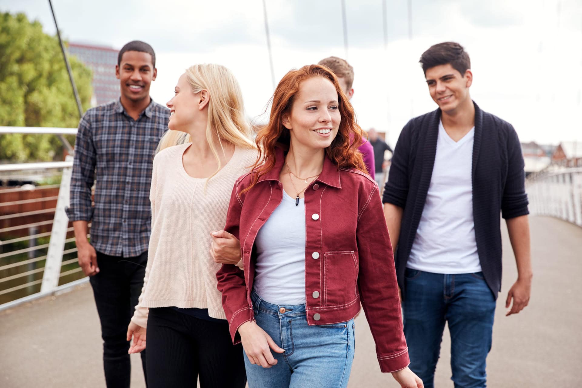 Grupo de jóvenes sonrientes caminando juntos
